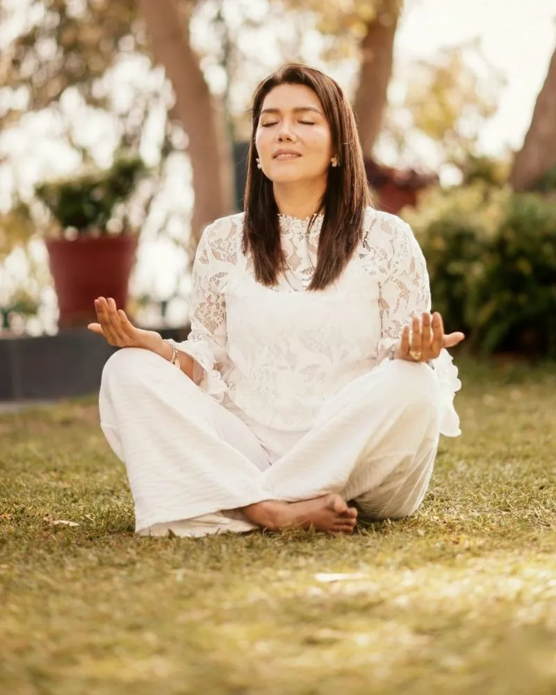 Deyssi Lobos en meditación, sentada en el jardín, vestida de blanco